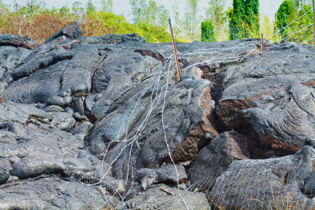 Wire fence destroyed by advancing lava in the town of Pahoa, Big Island, Hawaiiの写真素材