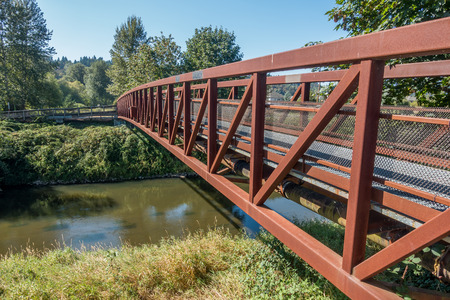 A metal walking bridge spans the Green River in Washington State.の写真素材