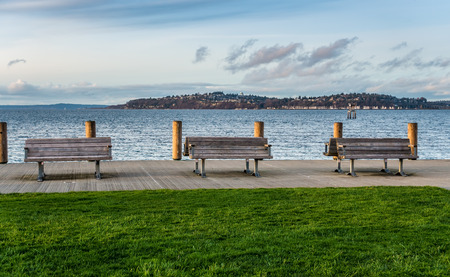 A view of three benches on the waterfron in West Seattle, Washington.の写真素材