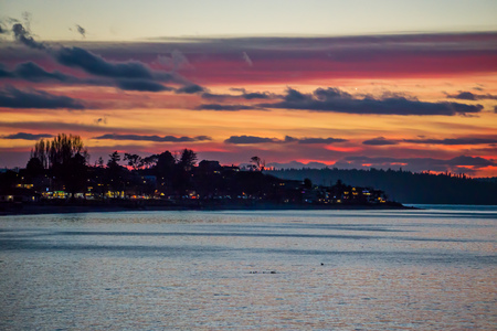 The sky is rich with colors as the sun set at Alki Beach in West Seattle, Washington.の写真素材