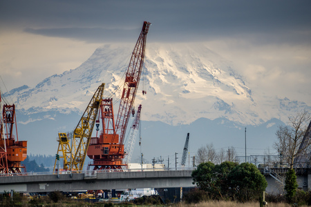 a view of a bridge, crane and Mount Rainier at the Port of Tacoma.