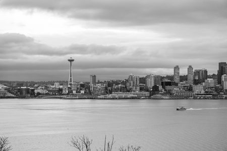 A boat cruises across Elliott Bay in front of the Seattle skyline.の写真素材