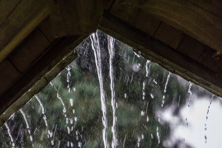 Raindrops stream off of a roof in Renton, Washington.の写真素材