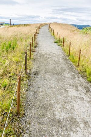 A dirt path leads up a small hill at Dune Peninsula Park in Tacoma, Washington.の写真素材