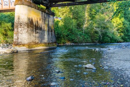 The Cedar River flows beneath a bridge in Maple Valley, Washington.の写真素材