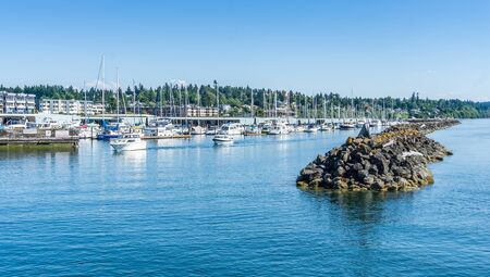 A view of the sea wall and marina in Des Moines, Washington.の写真素材