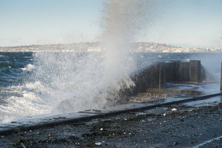 Waves crash on the waterfront at Alki Beach in West Seattle, Washington.の写真素材