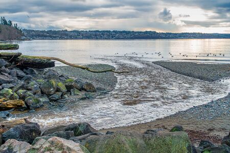 Dark clouds hang over smooth water of the Puget Sound.の写真素材