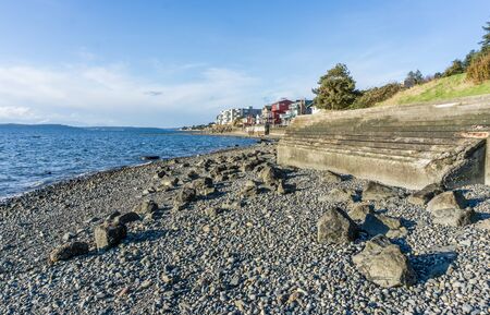 Stairs on a sea wall in West Seattle, Washington lead to the water.の写真素材