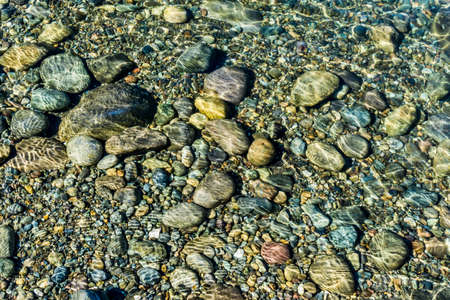 A background shot of rocks under clear water in Washington State.