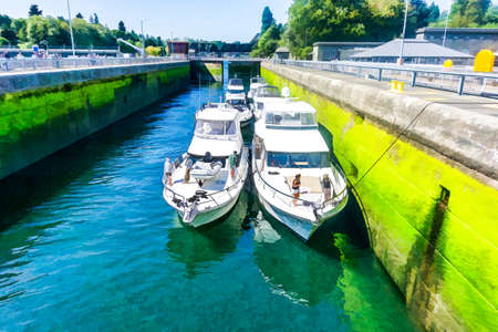 Photo-illustration of boats waiting for the water to rise at the Ballard Locks in Washington State.の写真素材