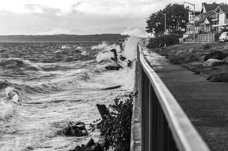 Waves crash against the shore in West Seattle, Washington on a stormy day.の写真素材