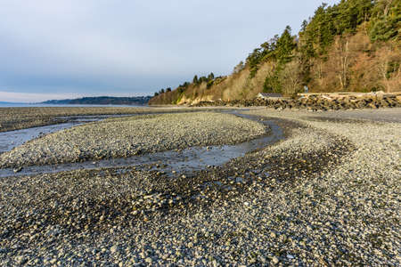 A stream flows onto the shoreline at Satlwater State Park in Washington State.の写真素材