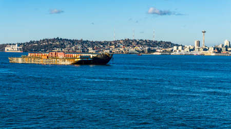 A shipping barge and the Seattle skyline in Washington State.の写真素材