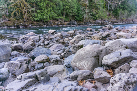 Large rocks line the Snoqaulmie River in Washington State.の写真素材