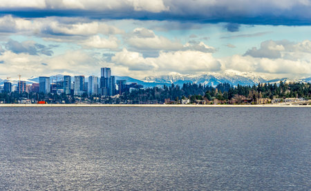 The cascdes mountain range has snow with Bellevue, Washington in front.
