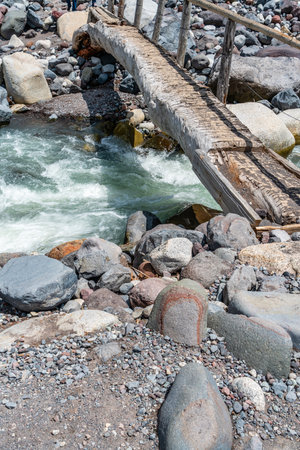 A small walking brdige spans rushing whitewater near Mount Rainier in Washingotn State.の写真素材