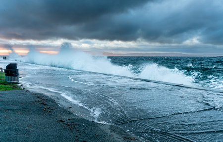Water explode on the sea wall at Alki Beach in West Seattle, Washington.の写真素材