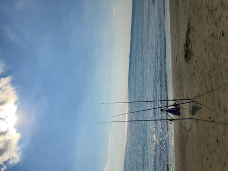 Fishing rods on the beach in the background of the blue skyの写真素材