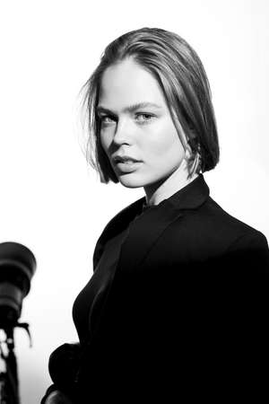 Stylish black and white portrait of a beautiful model. Isolated on white background. Epic light and shadows.の写真素材