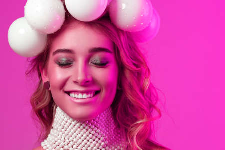 Beauty portrait of a girl with Christmas balls wreath on her head. The mood of the new year. Copy...