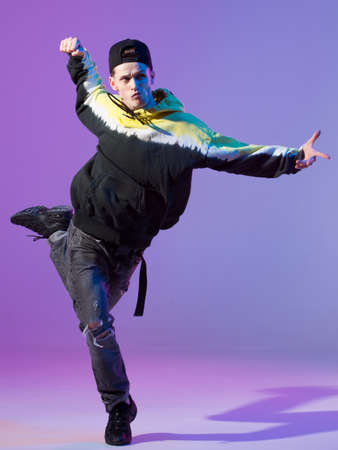 Breakdancing young man in hoodie and baseball cap. Dance school poster. Copy space. Battle...