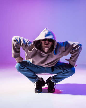 Breakdancing young man in hoodie with hair styling. Dance school poster. Copy space. Battle competition announcement.の写真素材