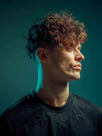 Modern man portrait in a neon light. Modern haircut. Mysterious and cool.の写真素材
