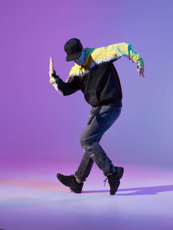 Breakdancing young man in hoodie and baseball cap. Dance school poster. Copy space. Battle competition announcementの写真素材