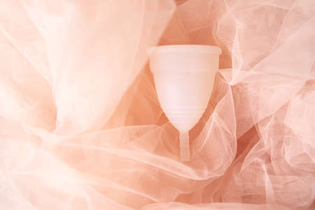 Menstrual cup eco friendly reusable and silicone in pink fabric, photography for feminist or woman blogの写真素材
