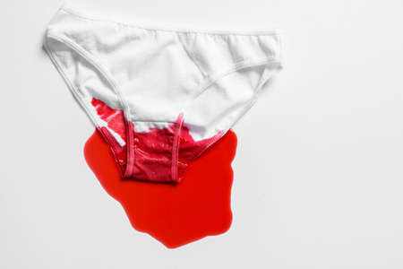 Menstrual fluid and womens underwear on white background, concept photo for womens or feminist blog, ad womens appsの写真素材