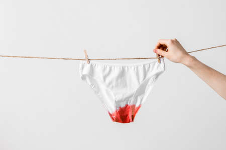 Woman hangs underwear on clothesline, concept content for feminist blog, poster about womens health and menstruationの写真素材