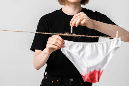 Woman hangs underwear on clothesline, concept content for feminist blog about womens health and menstruationの写真素材