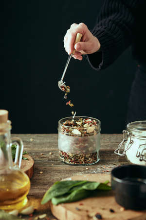 Close-up of hands preparing food in the kitchen. Cozy black background of home kitchen. The concept of healthy eating.の写真素材