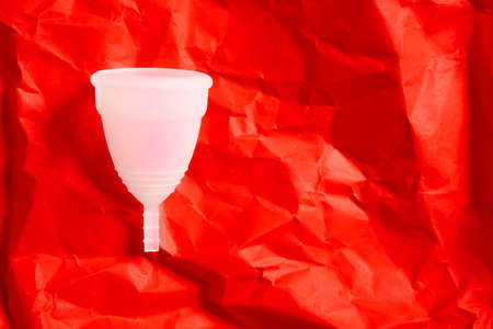 Menstrual cup white eco friendly reusable and silicone isolated on a red background with copy spaceの写真素材