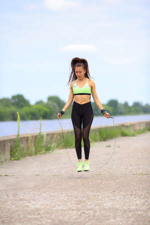 Pretty athletic girl doing exercises with a skipping rope, healthy sport womens lifestyleの写真素材