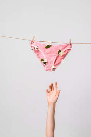 Feminist poster. Womens underwear on clothesline and womens hand raised up. Concept photography for feminist blogの写真素材