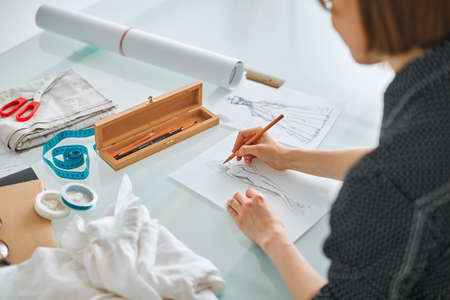 Young girl fashion designer working on new product in studio. Photography for blog or ad educational...