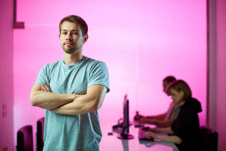 Young businessman and his creative design team at the office during developing a new project, pink backgroundの写真素材