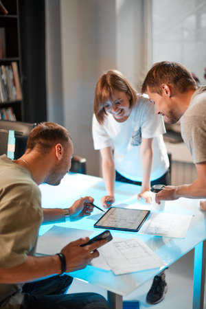 Young creative team of designers developing a new interior project using tablet in modern studioの写真素材