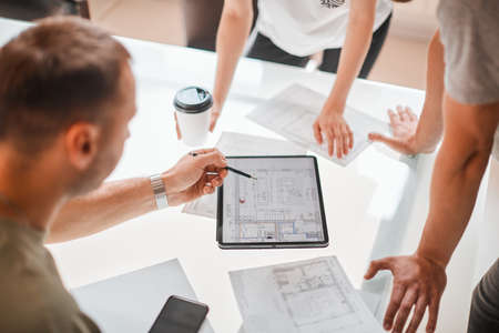 Young creative designers developing interior project using tablet in the office. Photography for...