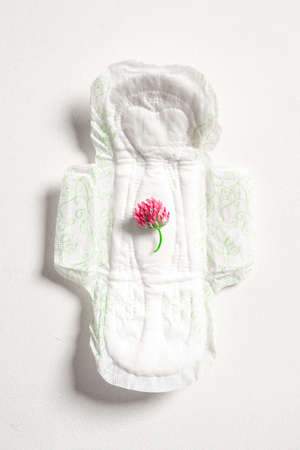 Soft white womens pad and flower clover isolated on white background. Close concept photography for...