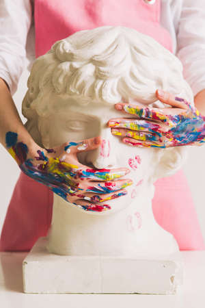Gypsum statue of Antinous head. Plaster statue in womans hands. Concept photography about art and genderの写真素材