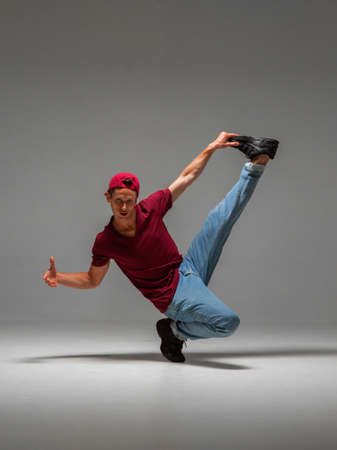 Cool guy breakdancer dancing lower break dance isolated on gray background. Break dance lessonsの写真素材