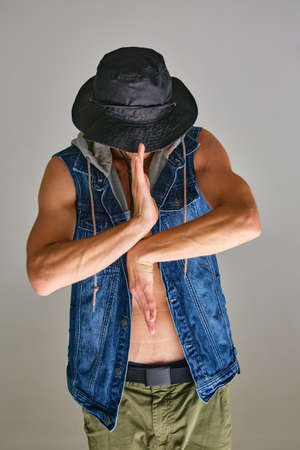 Guy breakdancer in panama hat dancing expressive dance in studio isolated on gray background. Dance school posterの写真素材