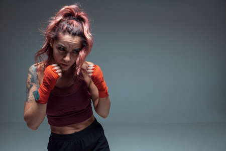 Large portrait of a female mixed martial arts fighter with a bandage on his hands