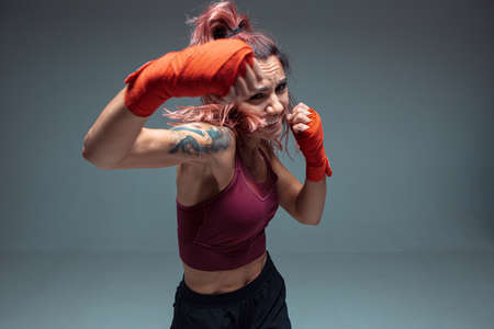 Large portrait of a female mixed martial arts fighter with a bandage on his hands