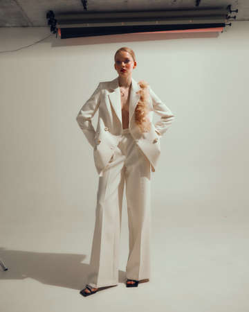 Romantic stylish modern young female model in white suit, studio portrait of pretty girl in festive costume, copy spaceの写真素材