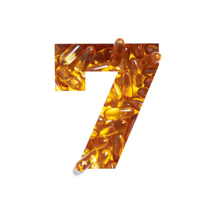 Omega supplement. Number seven made of fish oil pills and paper cut in shape of seventh numeral isolated on whiteの写真素材