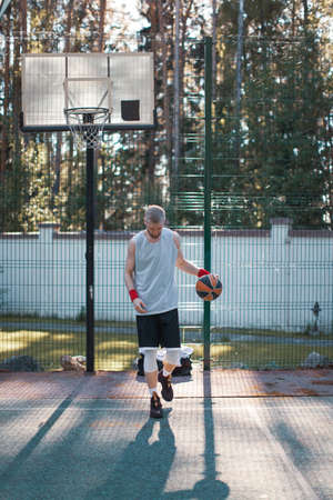 Professional male american basketball player exercising on court outdoors in summer in sunlightの写真素材